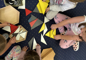 Dzieci układają kompozycję z figur geometrycznych.