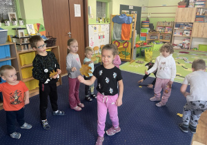 Dzieci tańczą z liśćmi do muzyki.