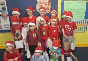 zdjęcie dzieci z grupy 1, dzieci ubrane na czerwono, w czapkach Mikołaja