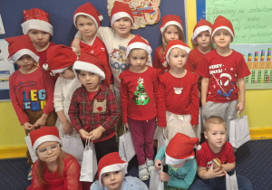 zdjęcie dzieci z grupy 1, dzieci ubrane na czerwono, w czapkach Mikołaja