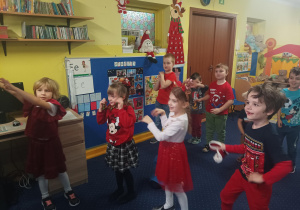 dzieci tańczą do muzyki przed tablicą interaktywną