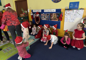 Pani rozdaje dzieciom prezenty od Świętego Mikołaja.