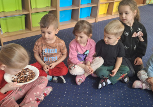 Dzieci siedzą w kole i wąchają herbatę.