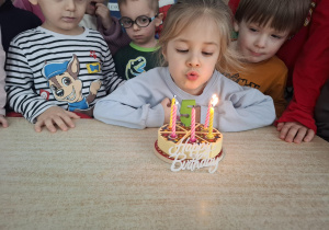 dziewczynka świętuje urodziny, dzieci składają jej życzenia