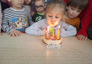 dziewczynka świętuje urodziny, dzieci składają jej życzenia