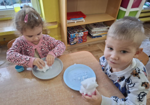 eksperymenty ze śniegiem, dzieci mają na talerzykach śnieg i różne akcesoria