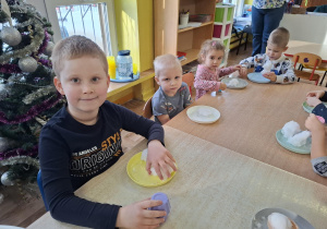 eksperymenty ze śniegiem, dzieci mają na talerzykach śnieg i różne akcesoria
