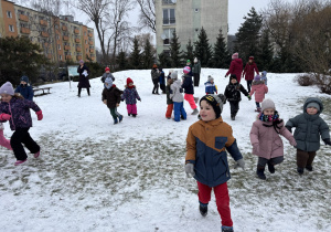 Dzieci biegają po ogrodzie.