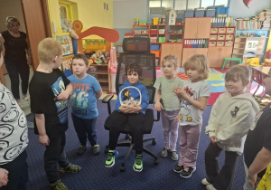 chłopiec świętuje urodziny, dzieci z grupy składaja mu życzenia, chłopiec częstuje cukierkami