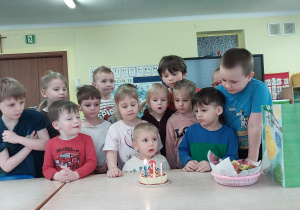 chłopiec świętuje urodziny, dzieci składają mu życzenia