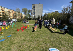 w ogródku przedszkolnym odbywają się sportowe konkurencje, w których uczestniczą dzieci