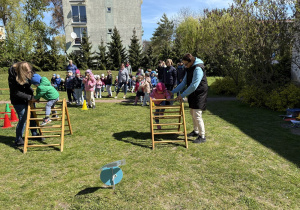 w ogródku przedszkolnym odbywają się sportowe konkurencje, w których uczestniczą dzieci