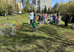 w ogródku przedszkolnym odbywają się sportowe konkurencje, w których uczestniczą dzieci