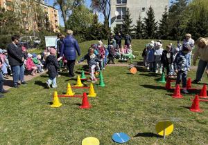w ogródku przedszkolnym odbywają się sportowe konkurencje, w których uczestniczą dzieci