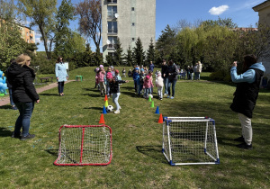 w ogródku przedszkolnym odbywają się sportowe konkurencje, w których uczestniczą dzieci