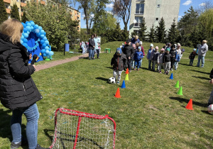 w ogródku przedszkolnym odbywają się sportowe konkurencje, w których uczestniczą dzieci