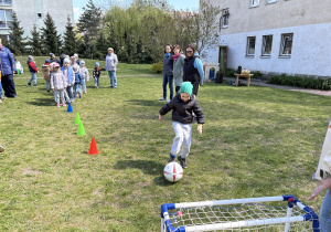 w ogródku przedszkolnym odbywają się sportowe konkurencje, w których uczestniczą dzieci