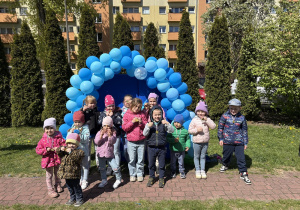 zdjęcie grupy dzieci na tle girlandy zrobionej z niebieskich balonów, na tablicy napis Niebieskie Igrzyska