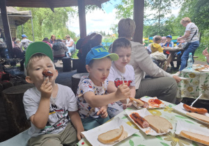 dzieci podczas wycieczki do pasieki w Lipce jedzą kiełbaski