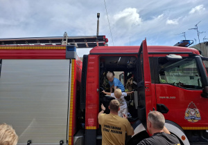 dzieci odwiedzają wnętrze wozu strażackiego