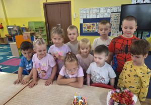 dziewczynka obchodzi urodziny, na stoliku widać tort z cyferką 7