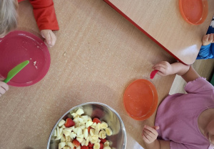 dzieci samodzielnie wykonują sałatkę z różnych owoców