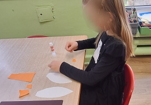 Dziewczynka wykonuje prace plastyczną.