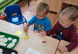 Dzieci malują muszelki wykonane z masy solnej.