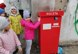 Hania wrzuca kartkę do skrzynki.