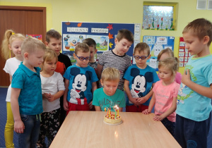 chłopiec dmucha świeczki na torcie