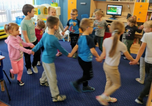 Dzieci stoją w kole i trzymają się za ręce