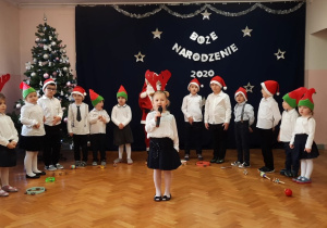 Dziewczynka prezentuje fragment wiersza Wandy Chotomskiej.