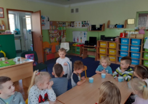 Dzieci siedzą przy stole. Czworo z nich ma jescze kubki z koktajlem.
