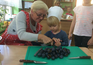 Zosia wyjmuje pestki ze śliwek.