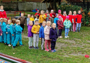 grupa dzieci na podwórku przedszkolnym, wykonują ćwiczenia gimnastyczne