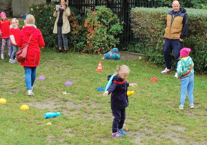 dzieci biorą udział w sportowej rywalizacji na podwórku przedszkolnym