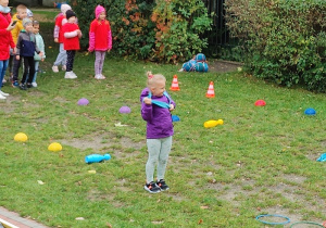 dzieci biorą udział w sportowej rywalizacji na podwórku przedszkolnym