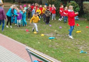 dzieci biorą udział w sportowej rywalizacji na podwórku przedszkolnym