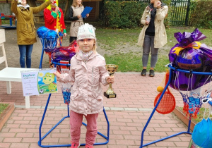 na pierwszym planie dziewczynka, która trzyma kosz do koszykówki