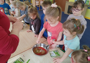 dzieci samodzielnie mieszają sos pomidorowy