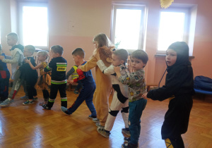 dzieci trzymają się za ramiona i bawią się przy muzyce