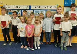 Wszystkie dzieci z grupy 4 pozują do zdjęcia. Starszaki prezentują swoje dyplomy.