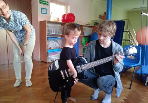 chłopiec gra na gitarze