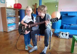 chłopiec gra na gitarze