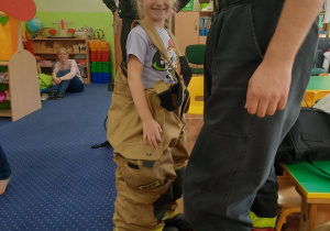 Dziewczynka w spodniach strażaka.