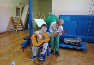 Chłopiec gra na gitarze.