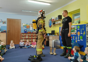 strażacy pokazują dzieciom sprzęt do ratowania życia i gaszenia pożarów