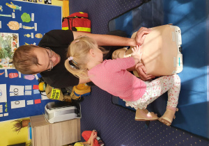 strażak pokazuje dzieciom sposób udzielania pierwszej pomocy