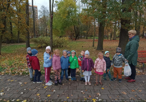 dzieci na spacerze w parku zbierają liście