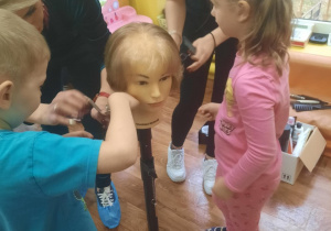 Dzieci obcinają włosy na główce do ćwiczeń.